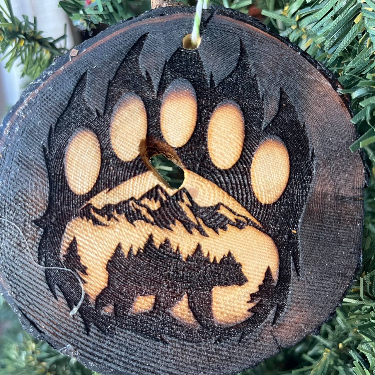Bear Paw Print Engraved Pine Wood Ornament – Rustic Wildlife Tree Slice Décor – Locally Sourced 3.25"-4" Round Ornament for Nature Lovers