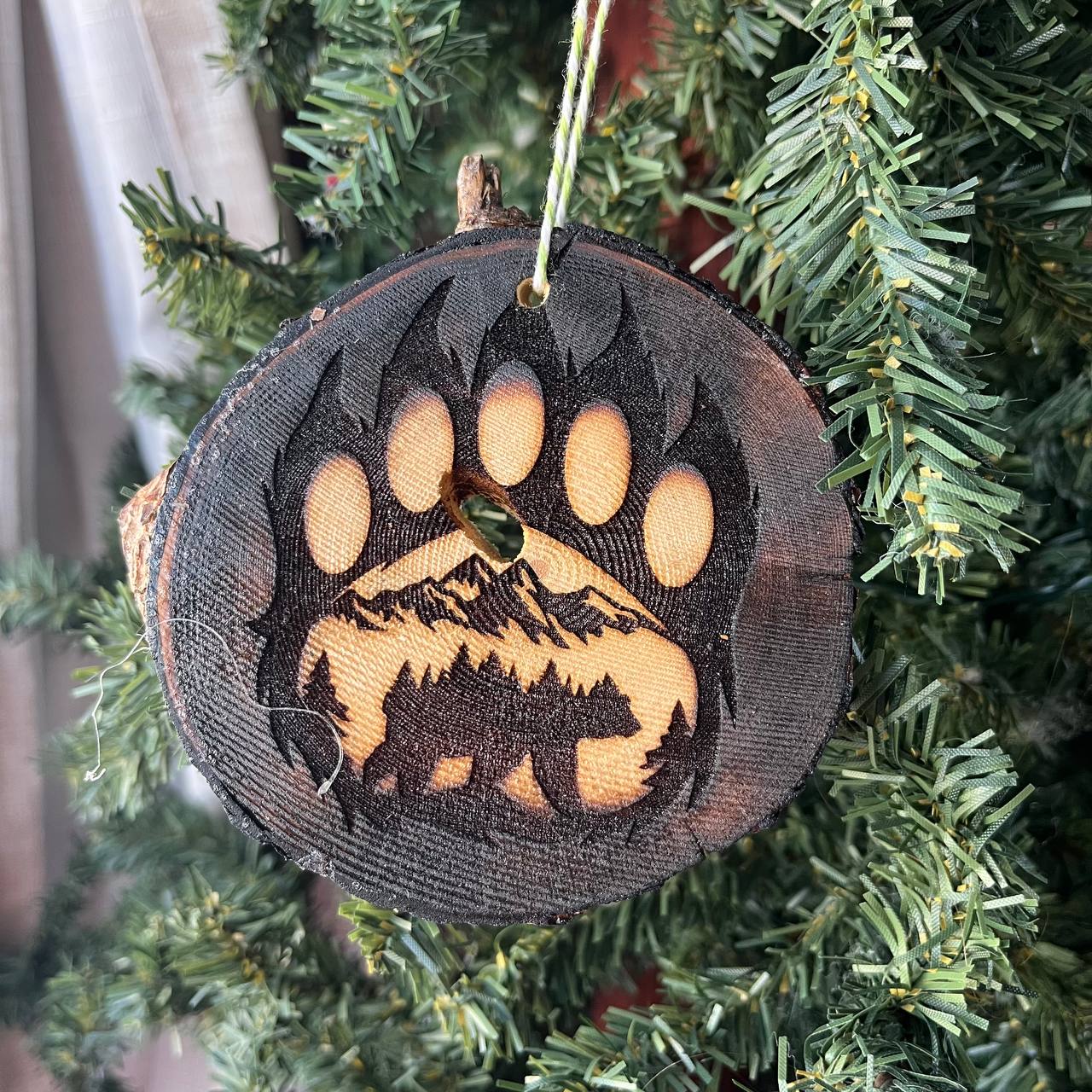 Bear Paw Print Engraved Pine Wood Ornament – Rustic Wildlife Tree Slice Décor – Locally Sourced 3.25"-4" Round Ornament for Nature Lovers