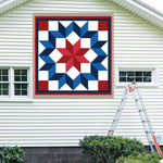 Carpenter Barn Quilt Pattern displayed on the exterior of a farmhouse, illustrating how the finished painted quilt block looks on a home.