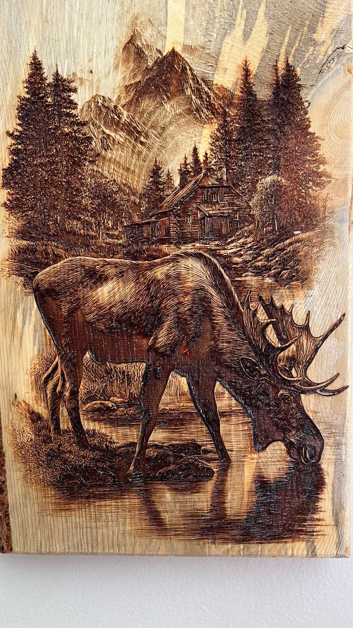 Wooden plaque with a moose and mountain landscape engraving