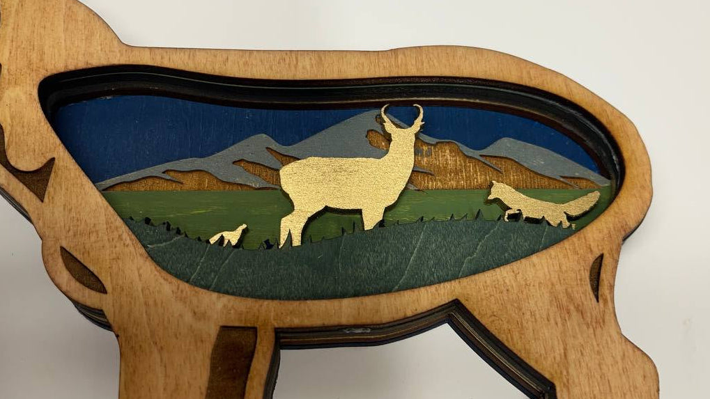 Wooden sculpture of a ram with a mountain scene inside