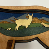 Wooden sculpture of a ram with a mountain scene inside