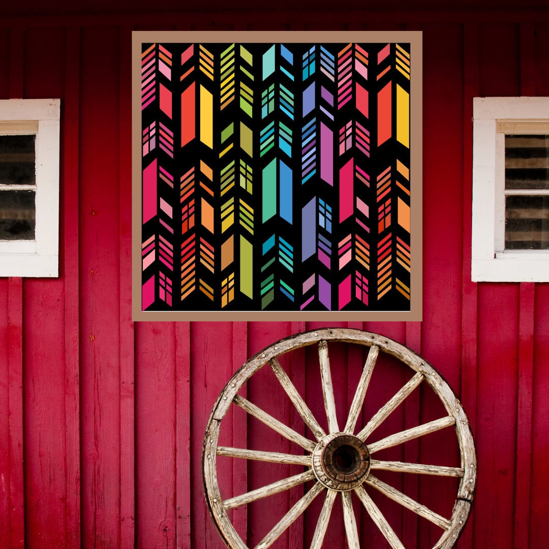 Feather Barn Quilt Pattern displayed on a rustic red barn with a vintage wagon wheel, showing the finished painted barn quilt outdoors.