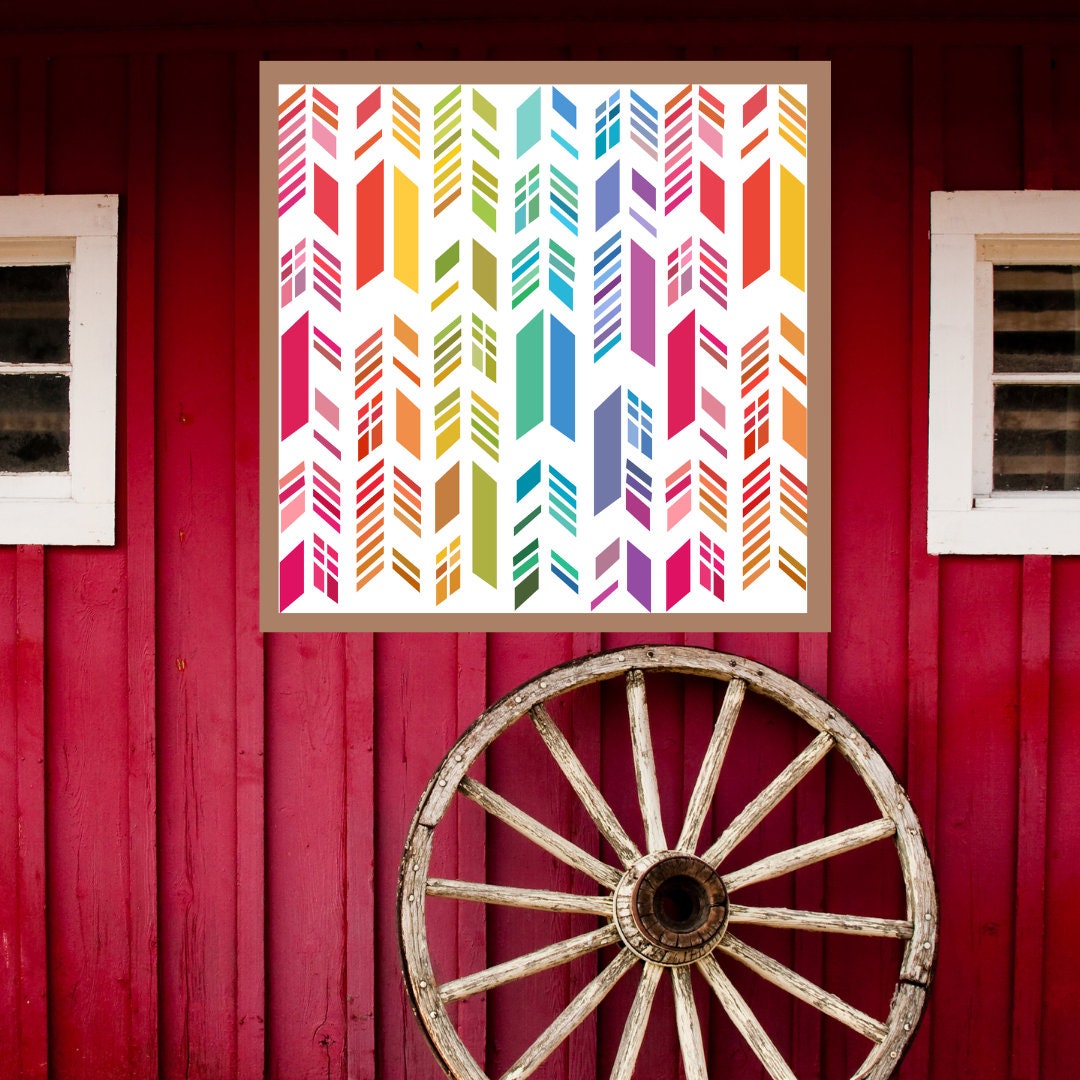 Feather Barn Quilt Pattern displayed on a rustic red barn with a vintage wagon wheel, showing the finished painted barn quilt outdoors.