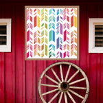 Feather Barn Quilt Pattern displayed on a rustic red barn with a vintage wagon wheel, showing the finished painted barn quilt outdoors.
