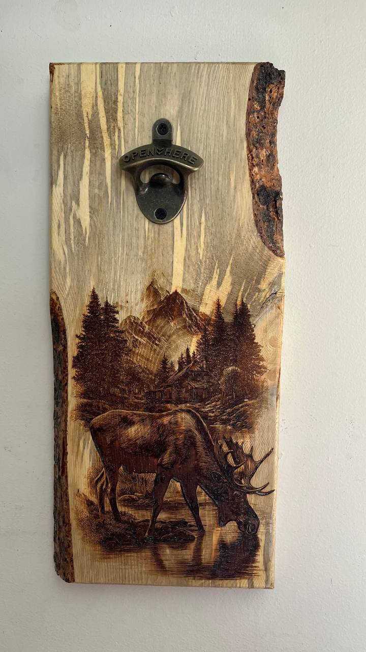 Wooden bottle opener with a moose and forest design on a white background