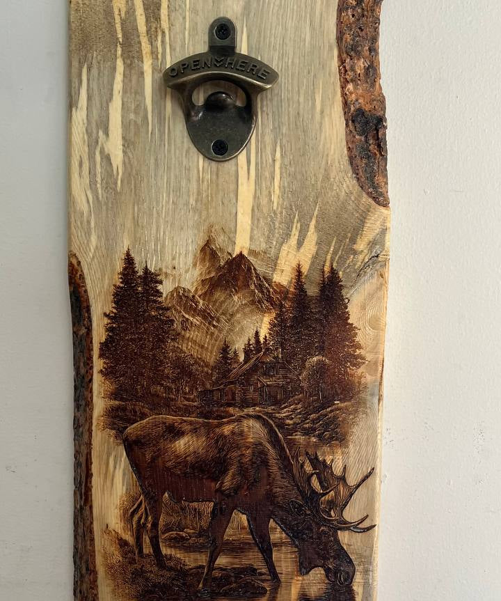 Wooden bottle opener with a moose and forest design on a white background