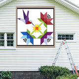 Hummingbird Barn Quilt Pattern displayed on the exterior of a farmhouse, illustrating how the finished painted quilt block looks on a home.