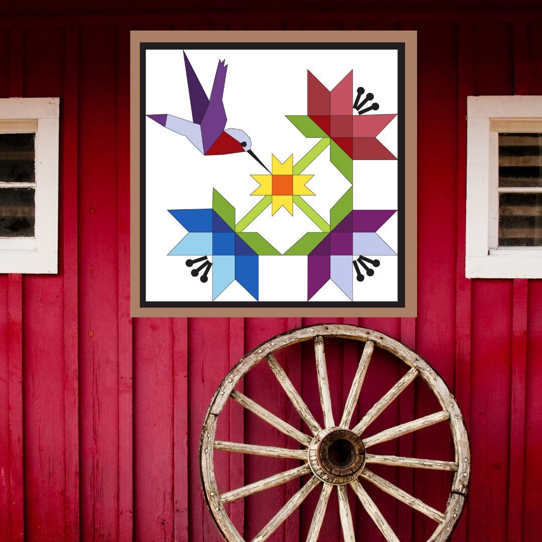 Hummingbird Barn Quilt Pattern displayed on a rustic red barn with a vintage wagon wheel, showing the finished painted barn quilt outdoors.