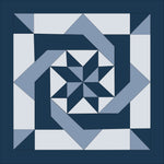 A digital image of a quilt with a geometric pinwheel and maze-like knot design, predominantly in blue and white colors.