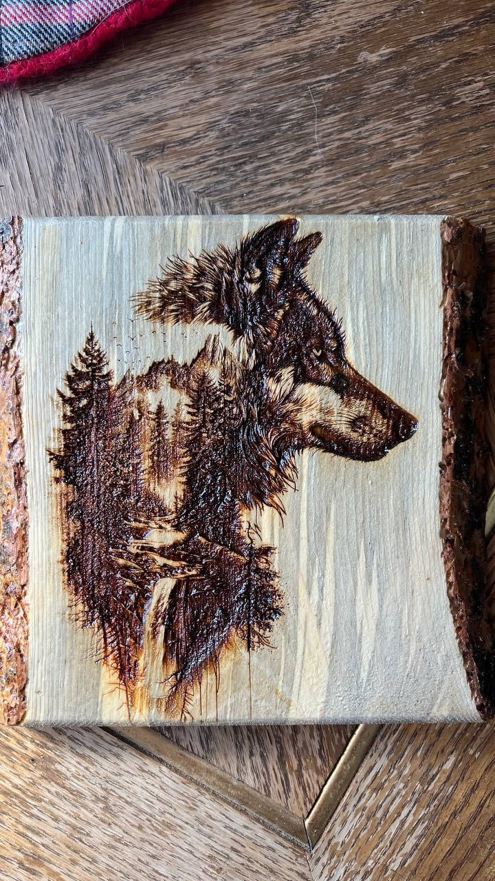 Wooden plaque with a burned design of a dog's head on a wooden surface
