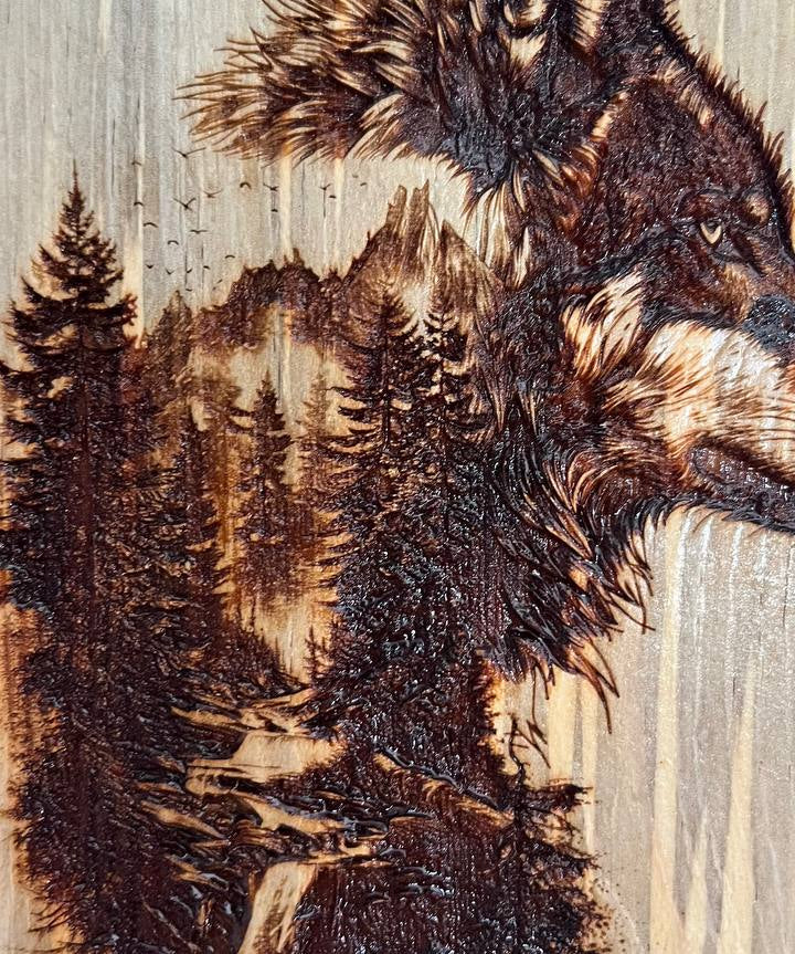 Wooden carving of two wolves with a forest background