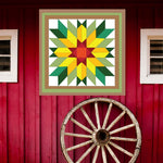 Sunflower Barn Quilt Pattern displayed on a rustic red barn with a vintage wagon wheel, showing the finished painted barn quilt outdoors.