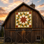 A large quilted wall hanging with a geometric star pattern in red, green, beige, and gold is displayed on the front of a rustic dark brown wooden barn, set against a mountain landscape at sunset.