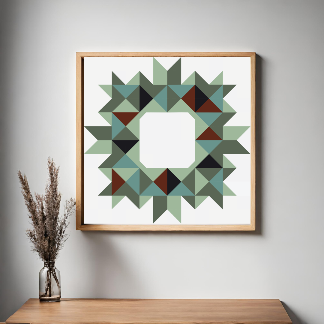 Framed geometric wall art hanging on a light gray wall above a wooden console table, with a glass vase of dried grass on the left. The artwork features a circular starburst pattern made of many triangles in muted green, teal, dark green, brown, and black on a white background, enclosed in a light natural wood frame.