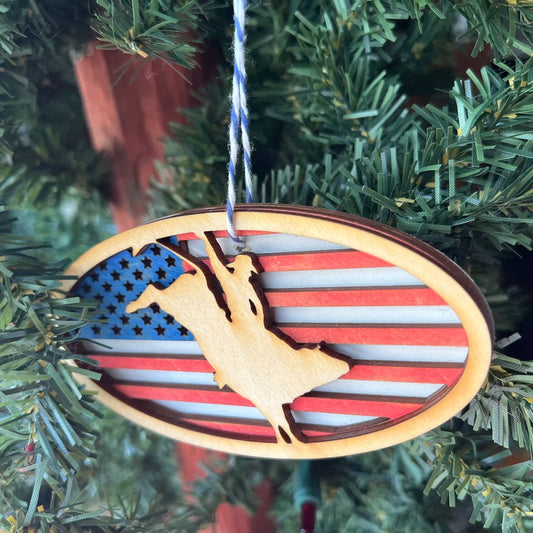 Patriotic Bull Rider Ornament – 4" Oval Wood Rodeo Christmas Ornament with American Flag Background for Cowboy & Western Decor