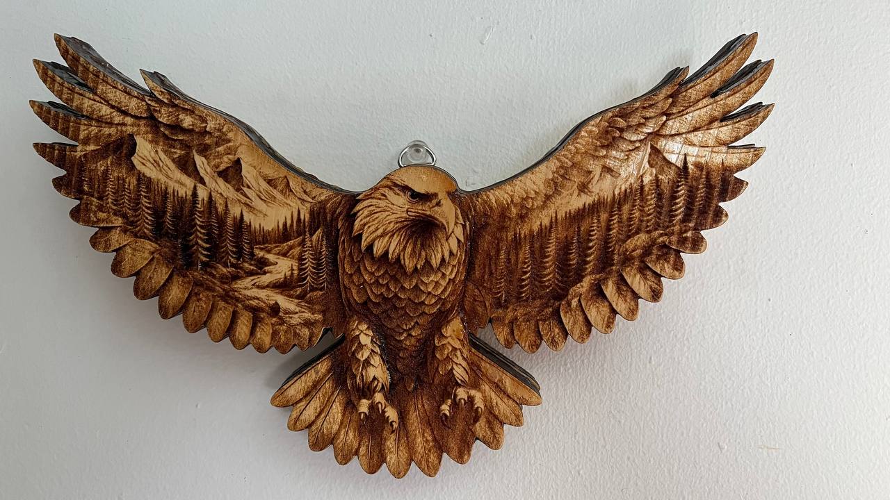 Wooden eagle sculpture with outstretched wings on a white background